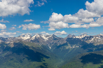 Spring mountain landscape with green mountains and snow peaks. Ski resort Krasnaya Polyana (Red Meadow). Sochi. Russia.
