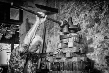 Grape harvest: old winemaker farmer working on a vintage wine press 