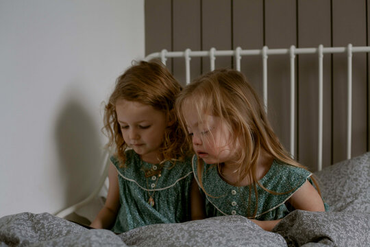 Twin girls with Down Syndrome reading bedtime story