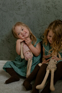 Twin girls with Down Syndrome playing with stuffed animals