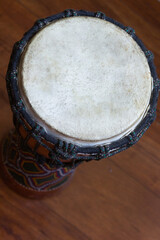 Top of djembe music instrument on brown wooden floor