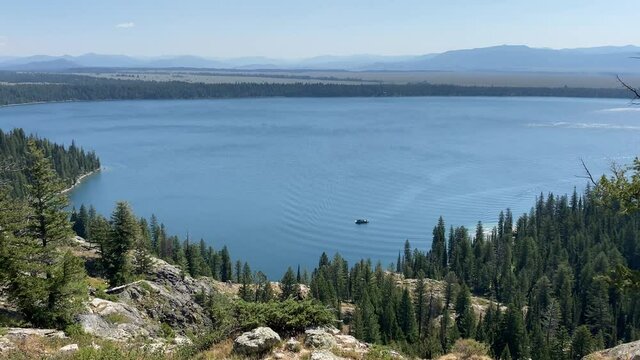 A ferry boat sails across Jenny Lake in Grand Teton National Park, as seen from Inspiration Point