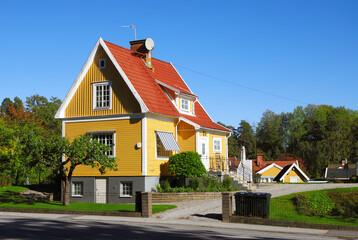 Yellow house single-family house with tiled gabled roof on two floors with basement built in the 1920s. - obrazy, fototapety, plakaty