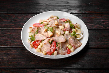 Delicious fresh salad with bacon and tomatoes with spices and greens