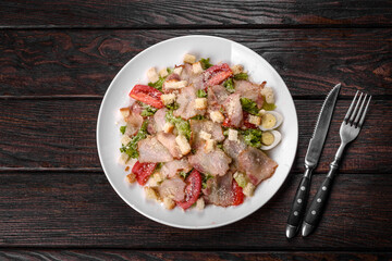 Delicious fresh salad with bacon and tomatoes with spices and greens