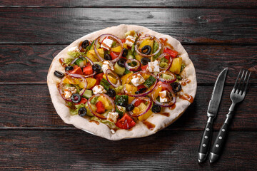 Tasty fresh Greek salad on a pita cooked for a festive table