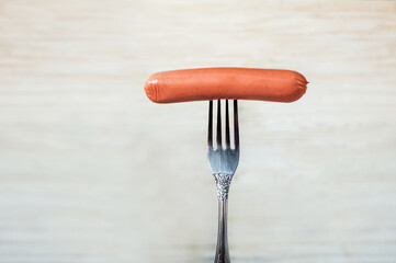 Raw sausage on fork close-up and copy space....