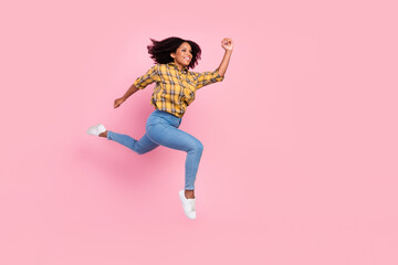 Photo of sweet cute dark skin woman dressed plaid shirt smiling jumping high running fast isolated pink color background