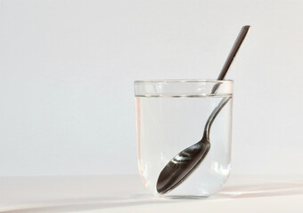 optical effect with a glass of water and a silver spoon