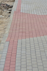 Bauma concrete paving stone pedestrian walkway under construction. White. Red.