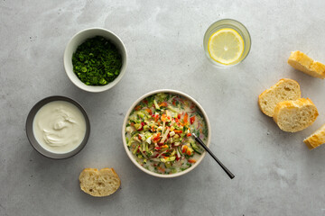Soup from fresh ripe vegetables with sour milk drink, Russian traditional soup okroshka, top view