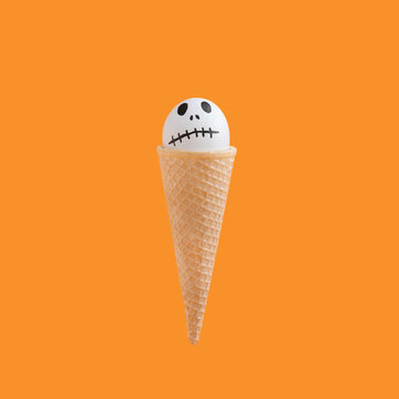Halloween concept with white egg painted as ghost character in ice cream cone