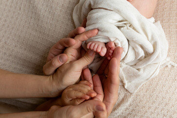 baby's feet in the hands of the older child and mom