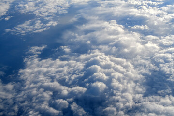 Obraz na płótnie Canvas Clouds and sky as seen through window of an aircraft