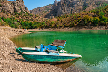 Fototapeta na wymiar Catamaran on the shore of a beautiful emerald mountain lake