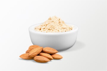 Almond flour in the bowl and almonds nut on the desk