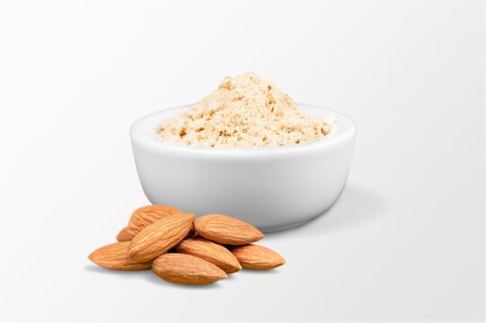 Almond flour in the bowl and almonds nut on the desk