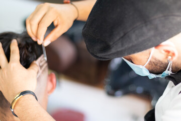 Fototapeta na wymiar Barber using face mask, doing Highborn and freestyle by hand. Concept advertising barber shop