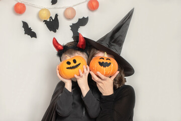 Mother and son have fun celebrating Halloween in a witch and devil costume. Family celebration