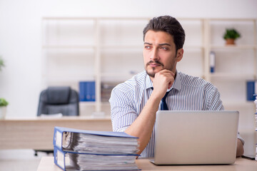 Fototapeta premium Young male employee and too much work in the office