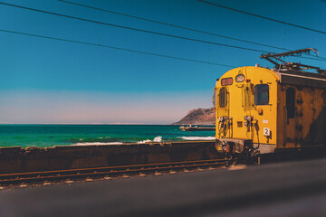 Obraz premium Yellow old train on a railway by the sea oin Cape Town, South Africa