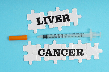 On a blue background, a syringe and puzzles with the inscription - LIVER CANCER
