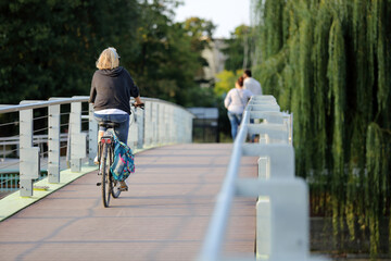 Kobieta jedzie na rowerze po moście we Wrocławiu. - obrazy, fototapety, plakaty