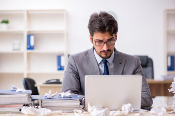 Young male employee and too much work in the office