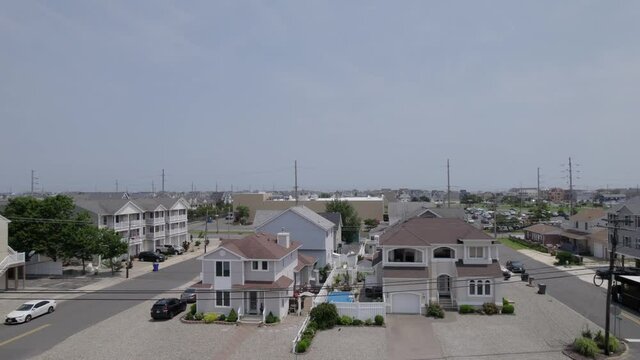 Drone slowly ascending upward revealing beach town houses