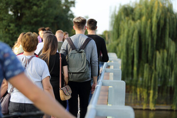 Para młodych ludzie, kobieta i mężczyzna z plecakami spaceruje po moście we Wrocławiu.	