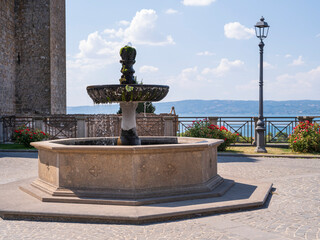 view to fountain and street lighter in italian city in summer day on lake Bolsena 