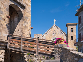 view to church and wooden bridge in medieval city in Italy in summer day