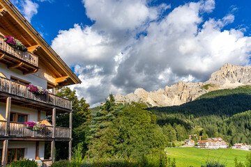 Fototapeta na wymiar Wanderurlaub in Obereggen in den Südtiroler Dolomiten: Hotel mit Blick aufs Weltkulturerbe Latemar mit seinen bizarren Felsformationen