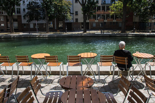 people in terrace in  cafe along Saint Martin canal in Paris