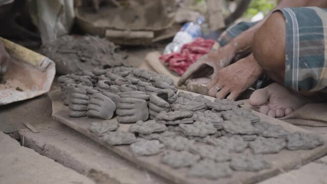 Unrecognized hands of poor sculptor making clay pots and idols, slow motion