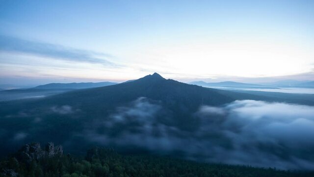 Scenery blue hour time lapse with cloud river drifting along mountain peak. Night to morning transition