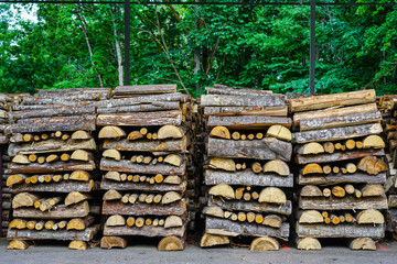 firewood stack, mostly made of halved tree trunks, stacked alternately lengthways and crossways