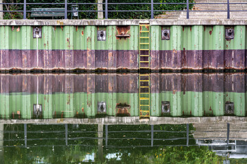 Fototapeta na wymiar Sheet pile wall at a landing dock reflecting in the Spree River in Berlin, Germany