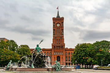 Neptune fountain in Alexanderplatz in Berlin, Germany, with Rotes Rathaus (Red Town Hall) in the...
