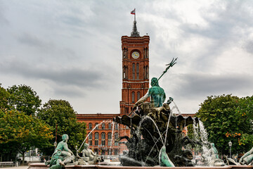 Neptune fountain in Alexanderplatz in Berlin, Germany, with Rotes Rathaus (Red Town Hall) in the...