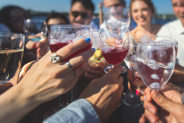 People celebrate and raise glasses, cheering with alcohol glasses with wine and champagne in the restaurant on corporate christmas birthday party event or wedding celebration