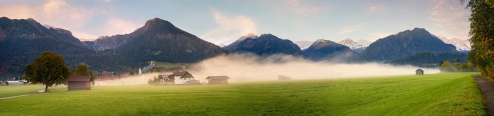 foggy morning scenery, tourist resort Oberstdorf landscape with mountains and green pasture