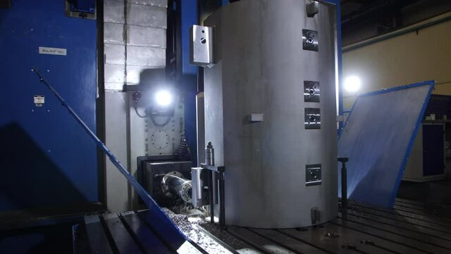 Making hole in metal casing of compressor with drilling machine cooled with water in light production plant workshop