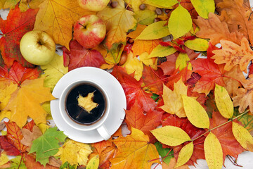 cup of coffee on autumn foliage top view