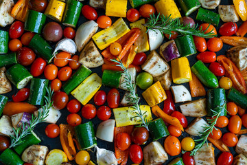 des légumes méditerranéens de toutes les couleurs découpés et éparpillés sur une plaque