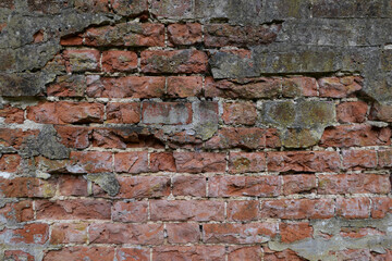 Old worn wall showing deeply textured red weathered brickwork with copy space