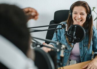 Happy woman recording podcast with crop black man