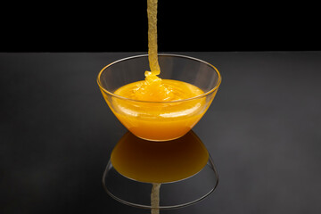 Fresh floral honey flows into a transparent plate in a mirror image. Organic Vitamin Health Food