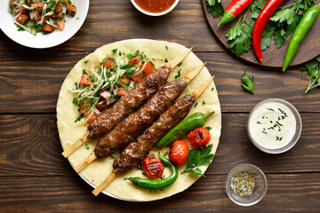 Turkish Adana Kebab with fresh vegetables on flatbread