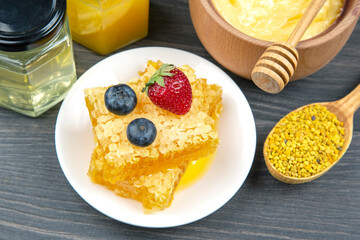 Fresh flower honey of different varieties, pollen and honeycomb with spoons on a wooden background. Organic Vitamin Health Food